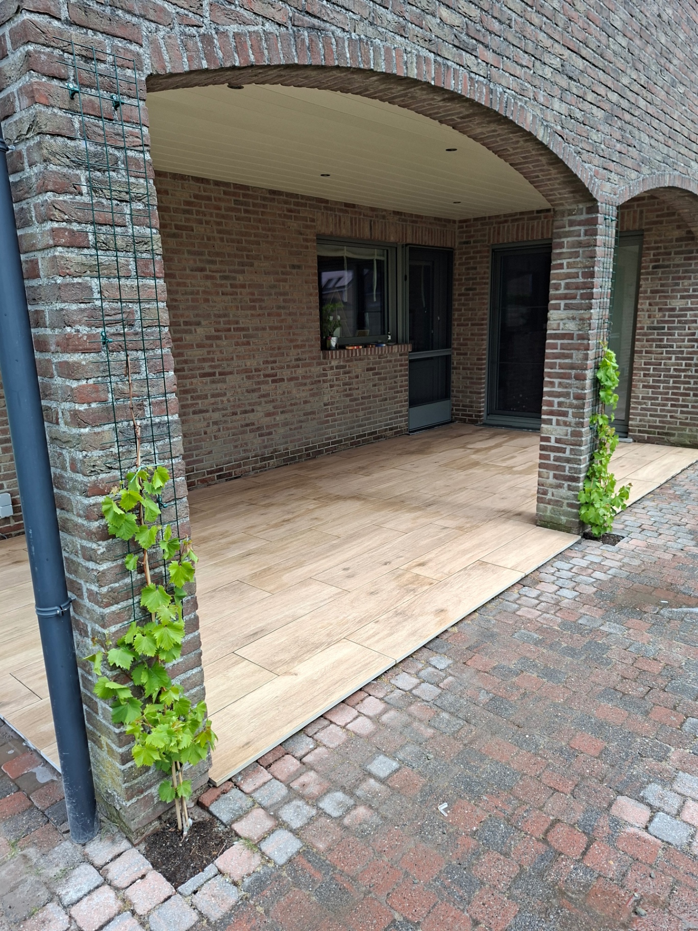 Aangelegd terras in keramische tegels met houtlook